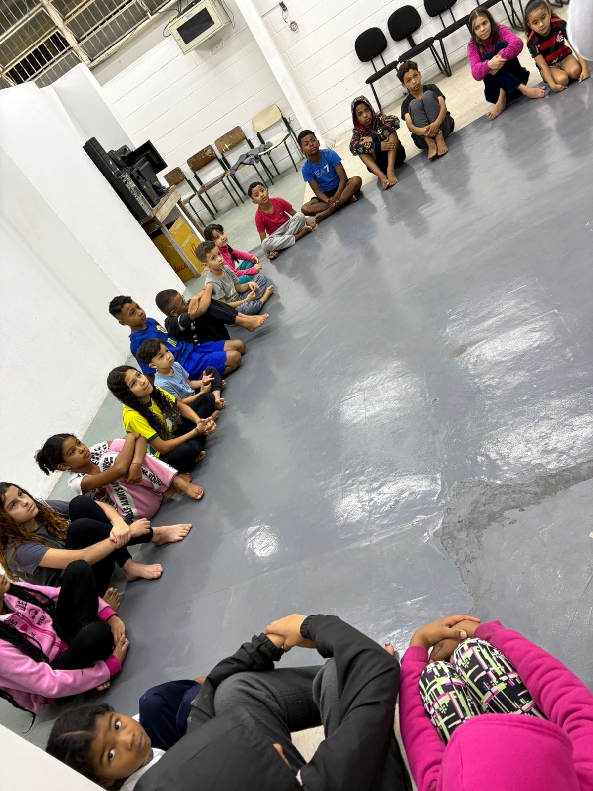 Participantes sentados em círculo durante a vivência de Capoeira