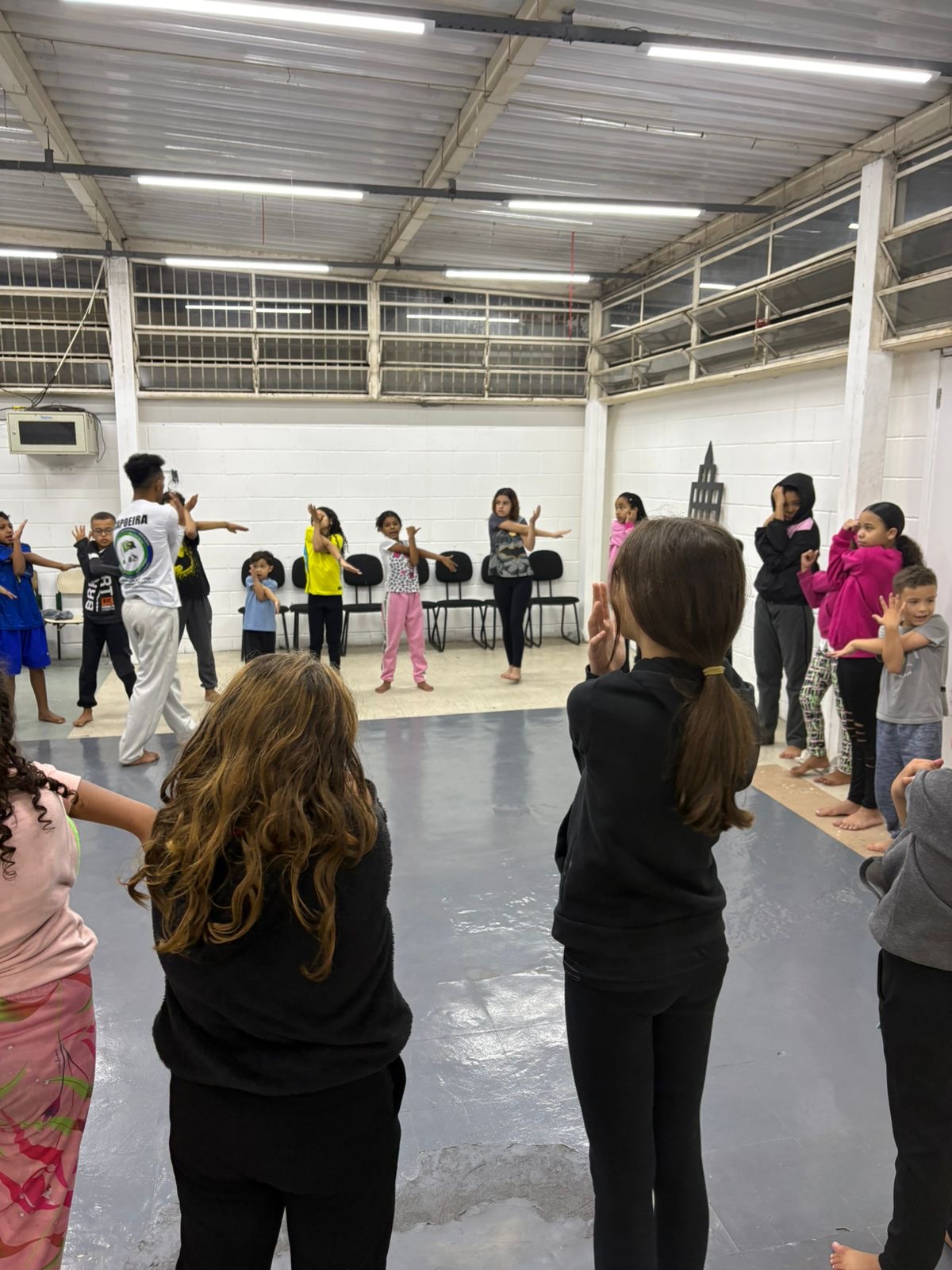Participantes acompanhando os movimentos do instrutor na aula prática